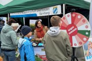 Personen stehen vor einer Scheibe mit unterschiedlichen Farbfeldern