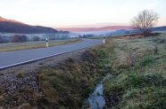 Straße entlang eines kleinen Bachlaufs