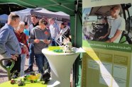 Personen stehen an einem Messestand
