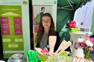 Frau steht an einem Messestand