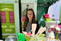 Frau steht an einem Messestand